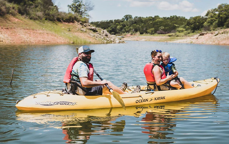 Hombre, mujer y niño en un kayak en un río